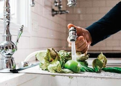 Person Cleaning Vegetables in Modern Kitchen