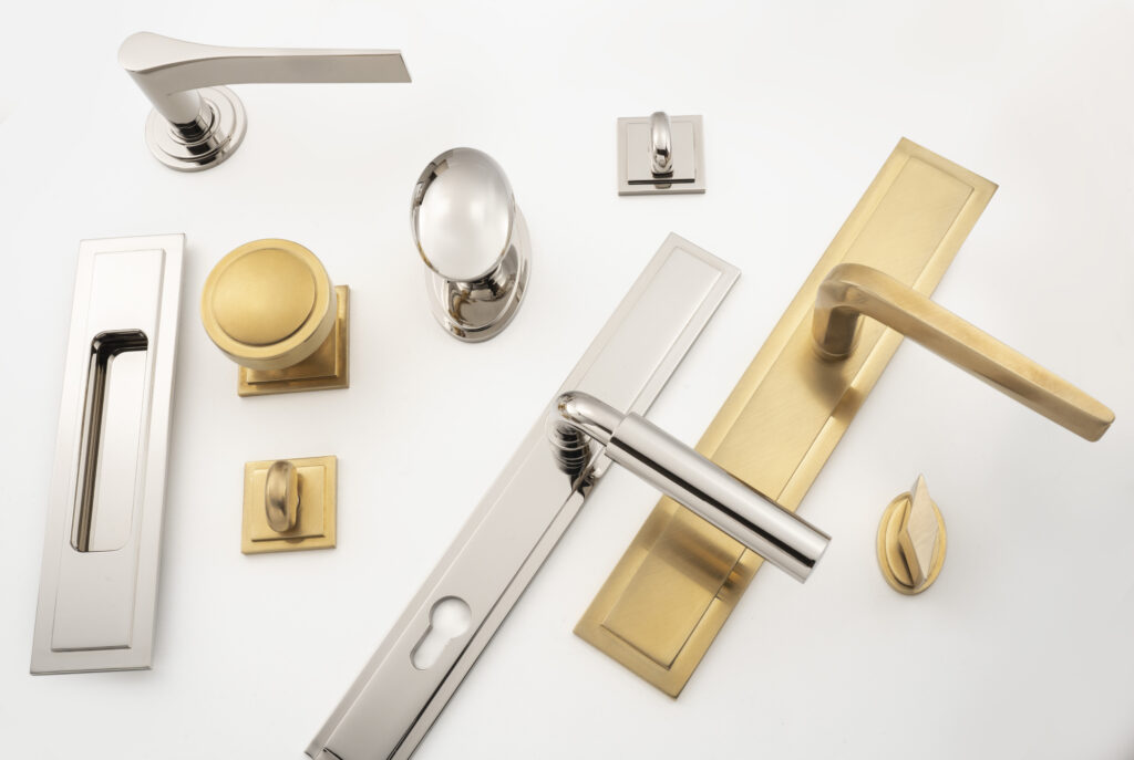 A collection of various doorknobs and handles on a white background, featuring different shapes and finishes, including chrome, brass, and brushed metal designs.